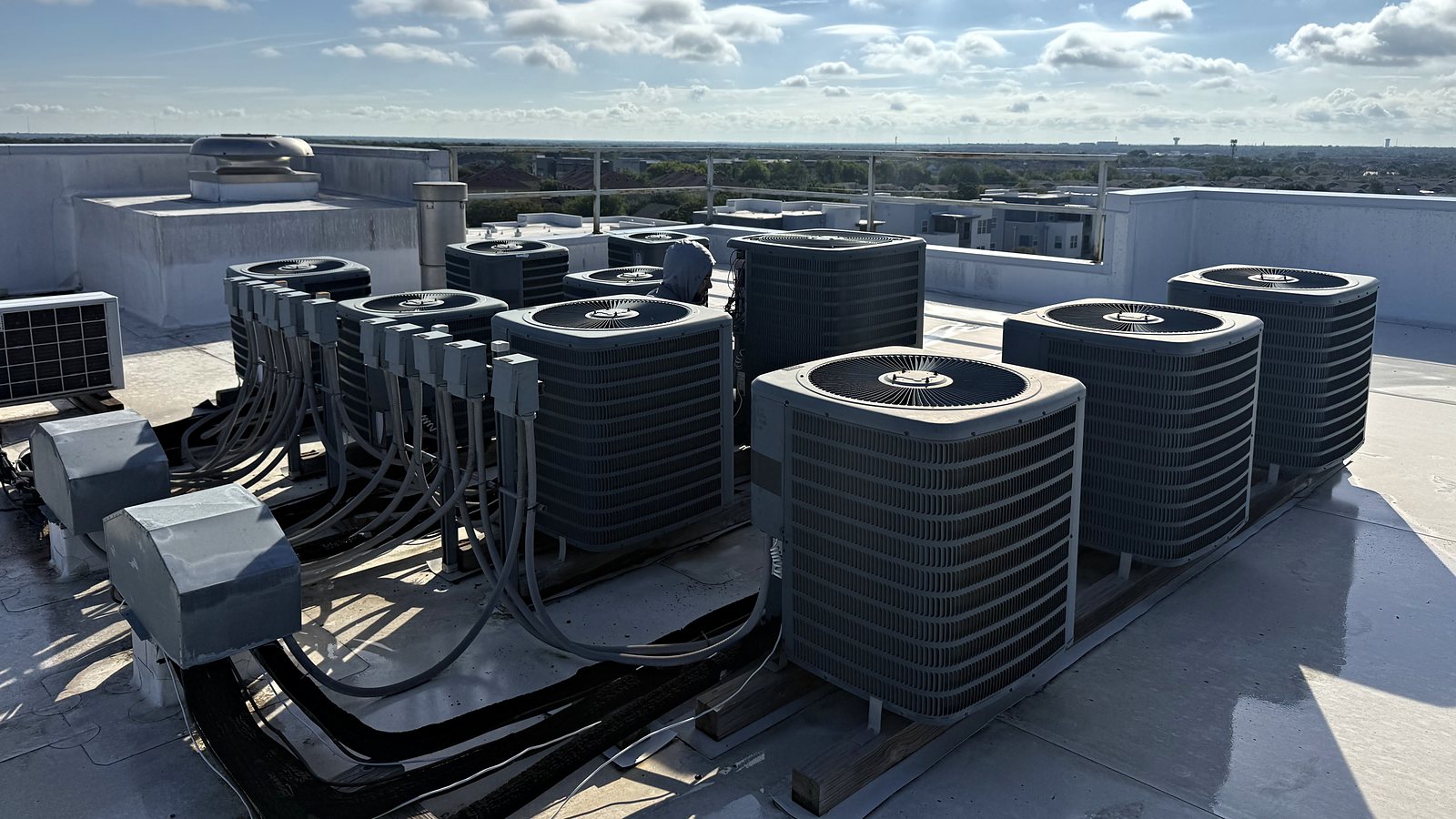 A rooftop bank of apartment air conditioning condensers at Park West in College Station, Texas